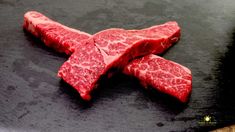 two pieces of raw meat sitting on top of a cutting board