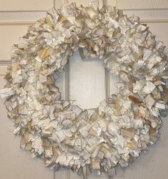 a wreath made out of books is hanging on the front door with a white frame