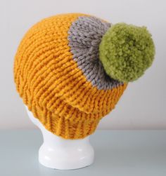 "Yellow Super Chunky Beanie Hat, knitted using 100% merino wool in yellow and grey and finished with a large green pom pom.  Features a ribbed brim and has a bit of slouch.   >Materials - 100% Merino Wool >Measurements - Ideal for a 21.5-23\" head, fitted around the brim with a slouch at the back.  >Care Instructions - Gently hand wash in cool water >More Hats - http://etsy.me/1skjQTY" Handmade Yellow Crochet Hat For Winter, One Size Yellow Crochet Hat For Winter, Yellow Hand Knitted Beanie Crochet Hat, Yellow Knit Beanie Hat, Yellow Yarn Hat One Size, Hand Knitted Yellow Crochet Hat One Size, Hand Knitted Yellow Crochet Hat, Yellow Hand Knitted Crochet Hat One Size, Yellow Hand-knitted Crochet Hat One Size