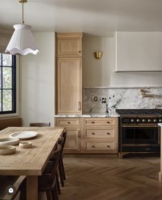 a kitchen with an oven, stove and dining room table in it's center