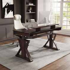 a desk with a computer on it in front of a bookcase and chair next to a window