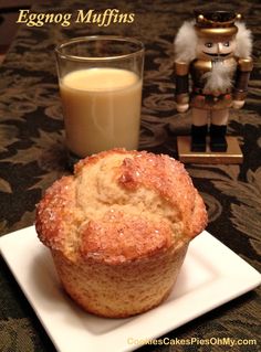 a muffin on a plate next to a glass of milk