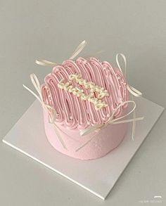 a pink cake with white icing on top