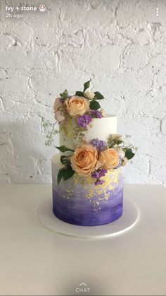 a white and purple cake with flowers on top