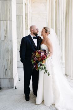 a bride and groom standing together in front of the lincoln memorial at their wedding day