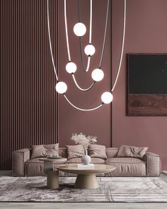 an elegant living room with pink walls and modern lighting fixtures hanging from the ceiling,