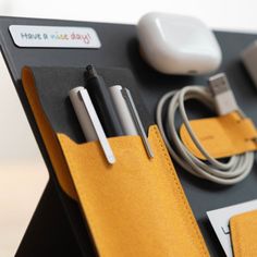 an assortment of electronic gadgets are displayed on a black table with yellow leather cases