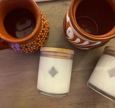 two jars with candles sitting next to each other on a table