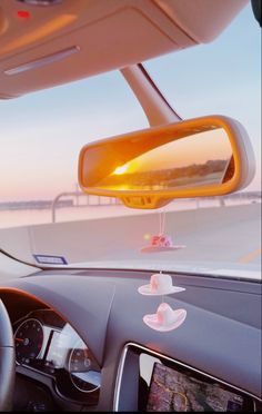 the sun is shining brightly through the rear view mirror on a car's dashboard