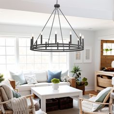 a living room filled with furniture and a large chandelier hanging from the ceiling