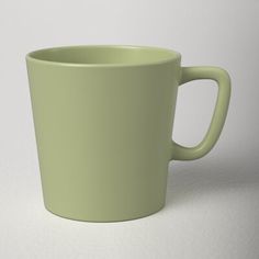 a green coffee cup sitting on top of a white table