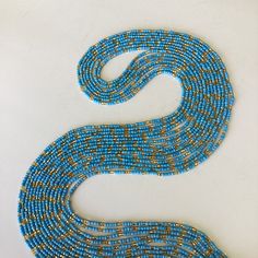 This women's waist bead is a unique and handcrafted accessory that is ready to ship. The beads are made with blue and gold glass beads, which provide a beautiful and eye-catching appearance. The colors of the beads are the same, but the design may vary, making each strand of waist beads unique and one-of-a-kind. The tie-on waist beads are easy to wear and adjust, ensuring a comfortable fit for the wearer. Each purchase is for one strand of waist beads, which is approximately 60 inches long. The Handmade Gold Waist Chain For Beach, Bohemian Gold Waist Chain With Colorful Beads, Gold Bohemian Waist Chain With Colorful Beads, Gold Waist Chain With Colorful Round Beads, Blue Waist Beads With Spacer Beads As Gift, Blue Colorful Waist Beads As Gift, Blue Beaded Waist Beads As Gift, Bohemian Beaded Chain Waist Beads, Bohemian Beaded Gold Waist Chain