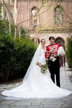 a bride and groom standing in front of a building