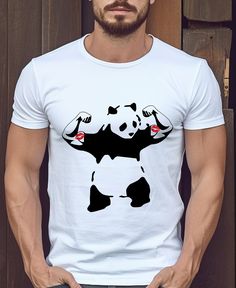 a man standing in front of a wooden door wearing a white shirt with a panda on it's chest