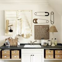 a bathroom with two sinks and several baskets on the wall above it, along with hanging utensils