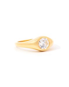 a yellow gold ring with a single diamond in the center, on a white background