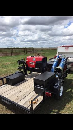 a trailer with two air tanks on the flatbed is parked in an open field