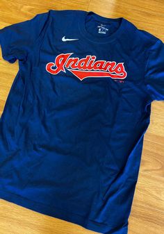 Nike Cleveland Indians Navy Blue Wordmark Short Sleeve T Shirt - 17320679 Blue Tops For College During Baseball Season, Blue Tops With Team Name For Baseball Season, Blue Baseball Season Top With Team Logo, Blue Tops With Team Logo For Baseball Season, Blue Baseball Fan Apparel Tops, Navy Sports T-shirt With Letter Print, Blue Fan Apparel Tops For Baseball Season, Blue Collegiate Tops For Baseball Season, Sporty Navy T-shirt With Logo Print