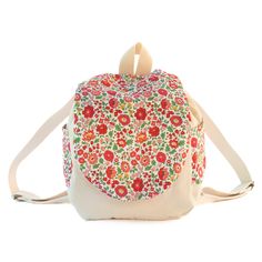 a white backpack with red and green flowers on the front, attached to a shoulder strap