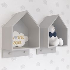 two gray shelves with white and gold decorations on the top one has a teddy bear in it