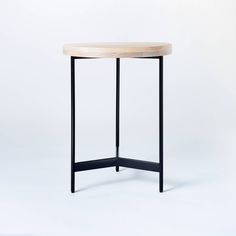 a round wooden table with black metal legs