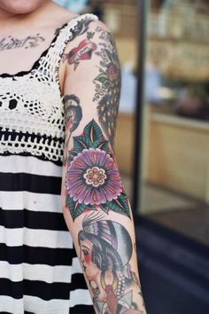 a woman with tattoos on her arm holding a cell phone