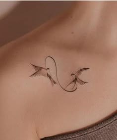 a woman's chest with two birds on it and the word love written in cursive writing