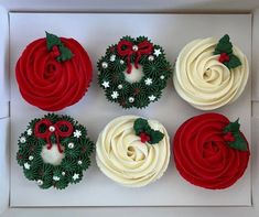 four cupcakes decorated with red and white frosting, holly wreaths and bows