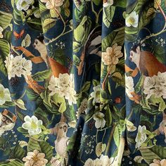 the curtain is decorated with birds and flowers on blue fabric, along with green leaves