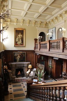 an ornately decorated living room with wood paneling and chandelier above the fireplace