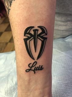 a person with a tattoo on their arm that reads lusi and has two crossed swords in the middle