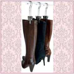 three pairs of high heeled boots hanging from hooks