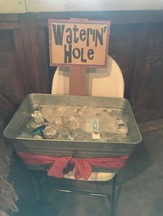 a sign that says watern'hole sitting on top of a chair in a bathroom