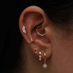 a woman's ear with three different types of piercings