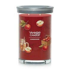 yankee candle with apples and cinnamons on the front, in a glass jar next to a