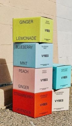 five boxes stacked on top of each other in front of a building with the words, lemonade, blueberry, mint, peach, ginger, and strawberry