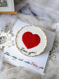 a red heart is on top of a card with the words i love you written in it