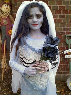 a woman dressed as a corpse bride holding flowers