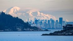 a view of a city with mountains in the background and snow on the top of it