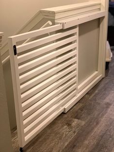 a white radiator sitting on top of a hard wood floor next to a wall