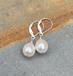 White Pearl Earrings, Sterling Silver Leverback Earrings. Dainty Dangle & Drop Earrings. June Birthstone.  The earrings are handmade using freshwater pearls and sterling silver components. The pearls are ivory white in color with great luster and subtle overtones of pink, they are teardrop shaped, and measure ~8.3 mm wide. As creations of nature, the pearls are not perfectly identical but very similar in size and shape. You have a choice of earring wires between simple lever back or French hook. The earrings are perfect for summer or really any time of the year, they measure ~1 1/16 to 1 3/16 inch (2.7 to 3 cm) long depending on earring wires. You may receive a remake of these classic white freshwater teardrop pearl sterling silver earrings made with pearls from the same lot. Pictures are White Sterling Silver Earrings For Birthday, Elegant Silver Earrings For Birthday, Nickel Free Drop Earrings For Birthday, Birthday Drop Earrings, Teardrop Pearl Earrings With Lever Back For Gift, Gift Pearl Drop Earrings With Lever Back, Adjustable Nickel-free Teardrop Pearl Earrings, Elegant Sterling Silver Earrings For Birthday, Elegant Pearl Drop Jewelry For Birthday