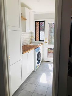 a kitchen with white cabinets and tile flooring