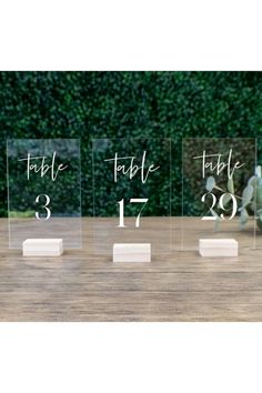 three clear acrylic tables with numbers on each side and one number in the middle