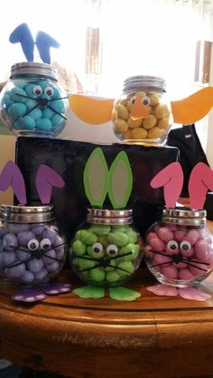 some jars with candy in the shape of bunnies and other candies on a table