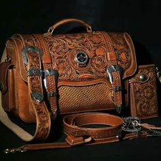 a brown leather bag sitting on top of a black table next to a pair of scissors