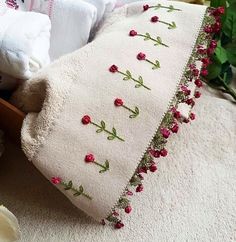 a white pillow with red flowers on it