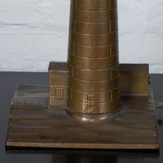 a small metal lighthouse on top of a black table