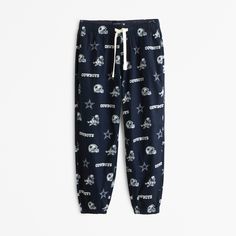 Our comfortable sleep joggers in a super soft cotton-blend fabric, featuring elasticated waistband, Dallas Cowboys graphic details, exterior drawcords, side pockets and banded cuffs. Navy Sweatpants With Elastic Waistband For Loungewear, Navy Relaxed Fit Joggers For Loungewear, Navy Cotton Joggers For Loungewear, Navy Cotton Bottoms For Loungewear, Navy Cotton Loungewear Bottoms, Sporty Blue Cotton Sleepwear, Sporty Blue Sleepwear For Loungewear, Cozy Cotton Sleepwear For Leisure, Sporty Cotton Sleepwear With Elastic Waistband