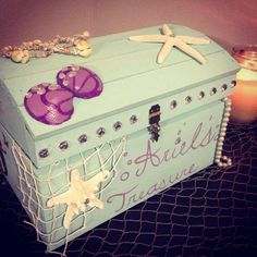 a blue box with purple shoes on it sitting next to a candle and starfish