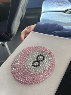 someone is holding up a piece of paper with sequins and the letter b on it